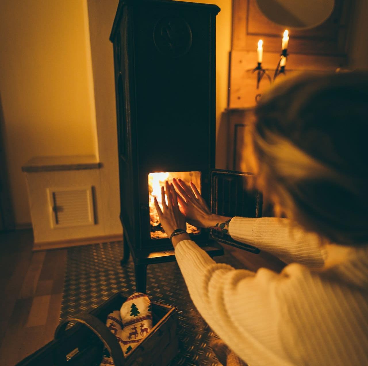 Femme se réchauffant les mains près du feu