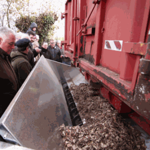 Un camion a fond mouvant déverse des palquettes dans le circuit l'alimentation d'une chaudière à bois pour chauffage communal