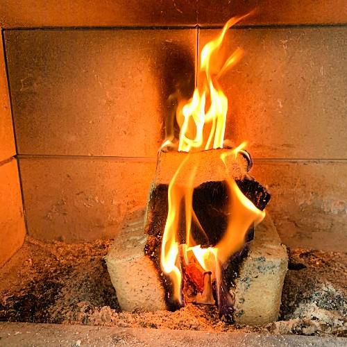 3 briquettes de bois densifié rectangulaires enflammées