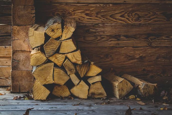 quelques bûches fendues stockées dans le coin d'une maison en bois