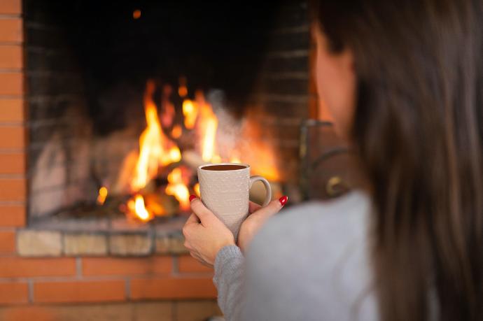 Femme dégustant une tisane au coin du feu