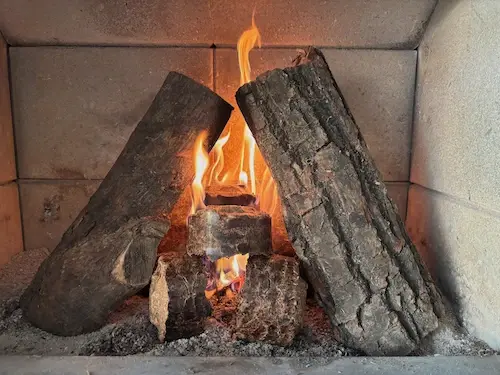 Comment allumer un feu de cheminée avec bois traditionnel et buches compressées